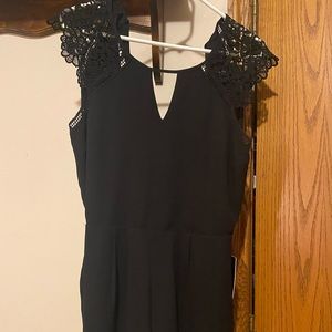 Black romper with lace detail. Open back